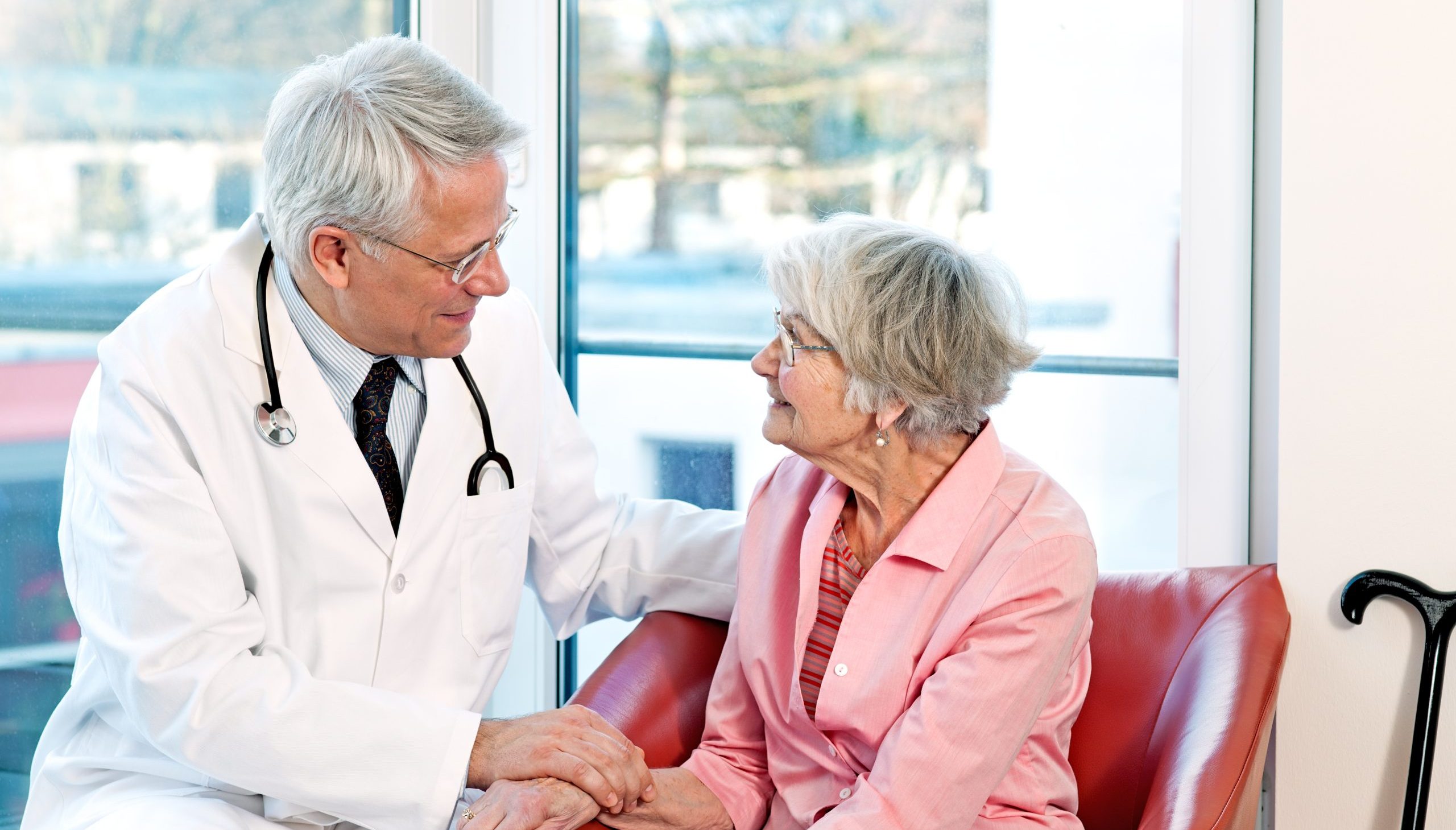 Friendly doctor reassuring an elderly woman.