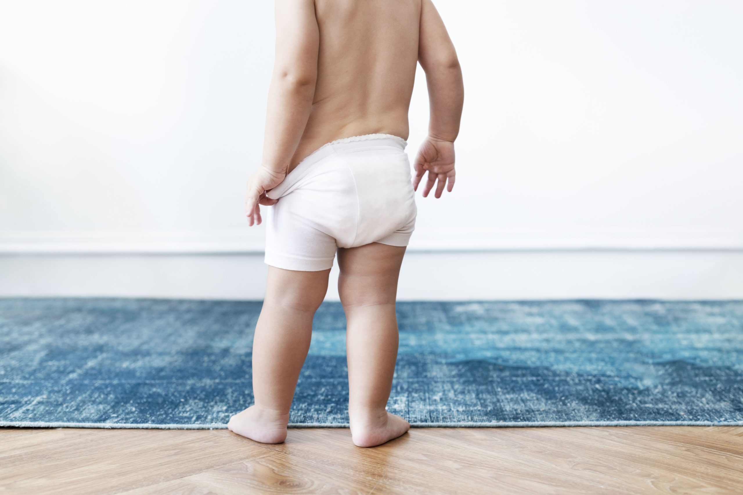 Baby boy pulling on his diapers